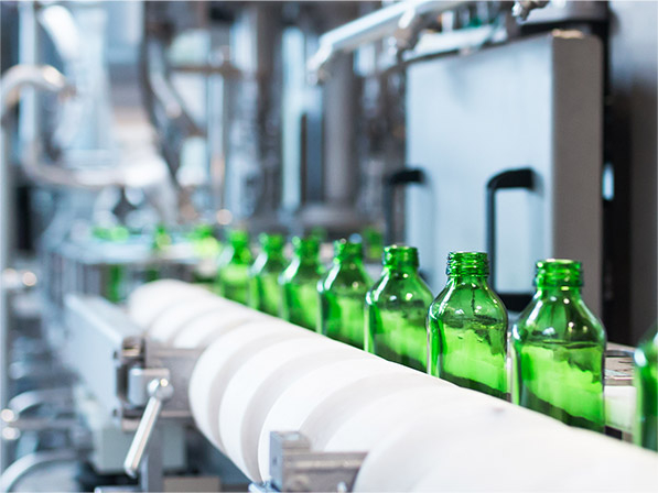 Green glass bottles on conveyor belt